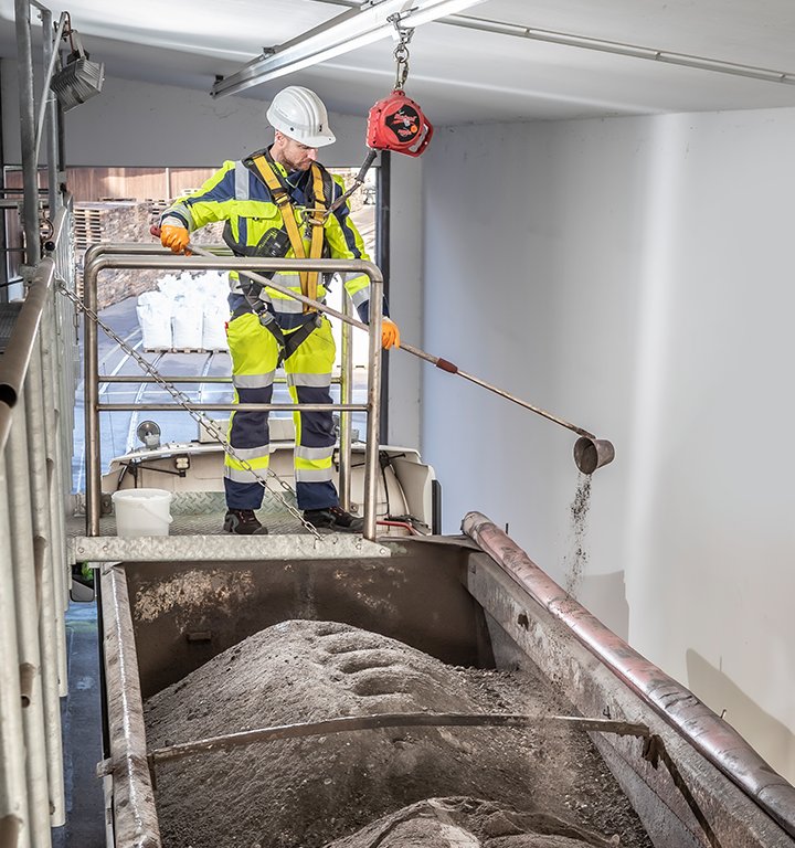 Bildmotiv eines Mitarbeiters bei der Probeentnahme eines Abfallstoffs