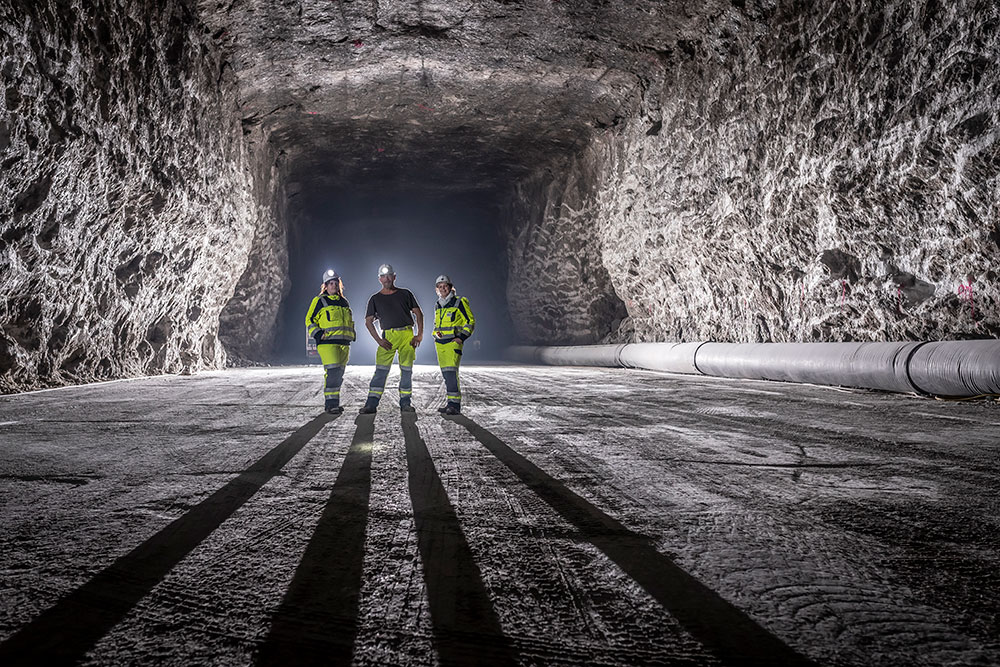 Bildmotiv einer untertägigen Salzkammer, in der drei Personen des Entsorgungsteams stehen